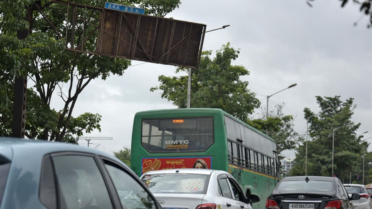 The rusted signboard dangled precariously on the Outer Ring Road near Kasturinagar, a stretch used by thousands of commuters daily. Credit: DH Photo/Pushkar V