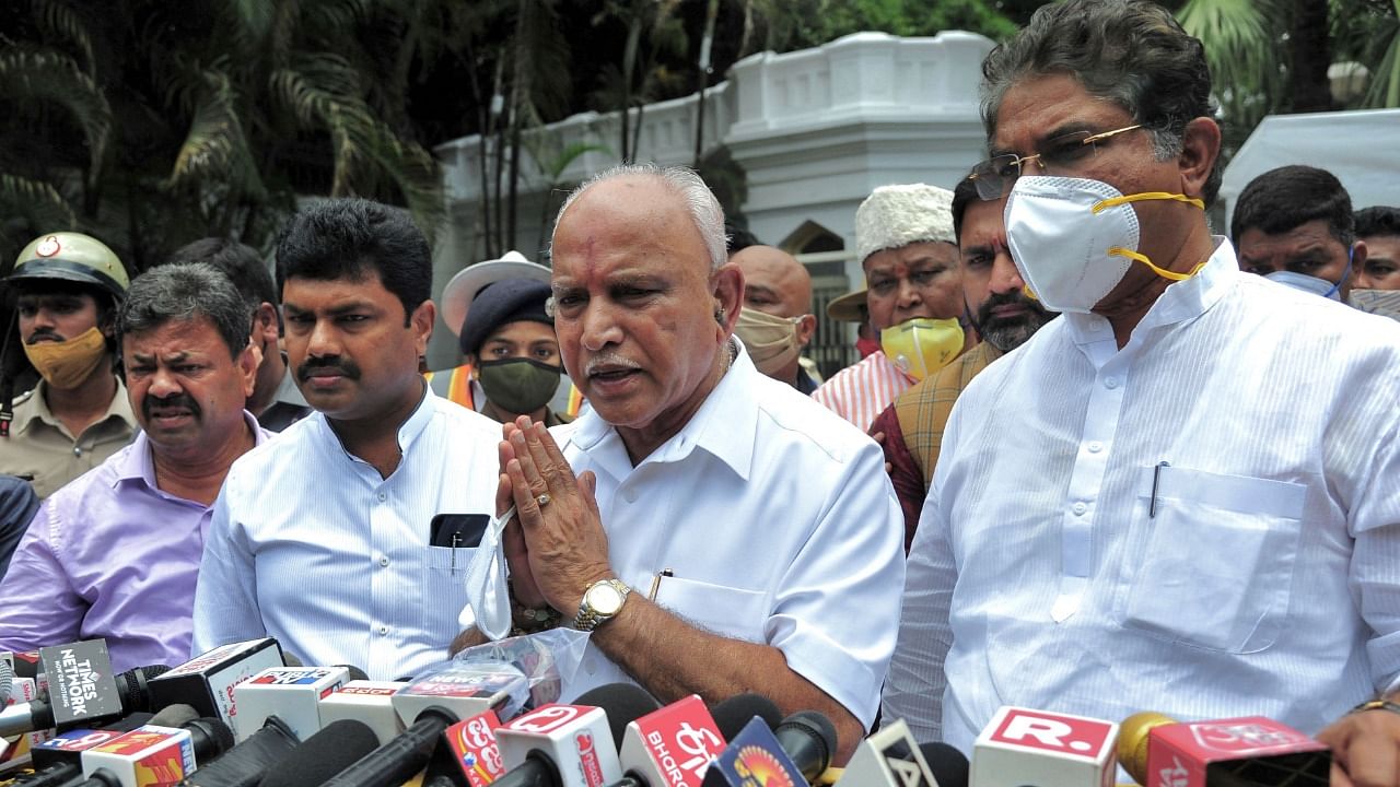 Karnataka chief minister B S Yediyurappa (C) gestures as he speaks to the medias outside the Governor's official residence Raj Bhavan after tendering resignation to his post. Credit: AFP Photo