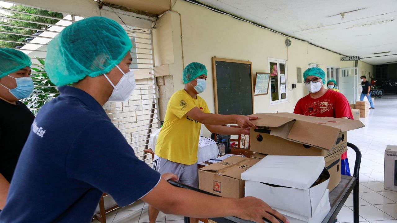 Healthcare workers distribute food at a catholic church training center turned into a self-isolation shelter for Covid-19 patients. Credit: Reuters Photo
