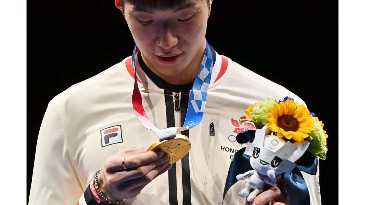 Gold medallist Hong Kong's Cheung Ka Long looks the medal as he celebrates on podium. Credit: AFP Photo