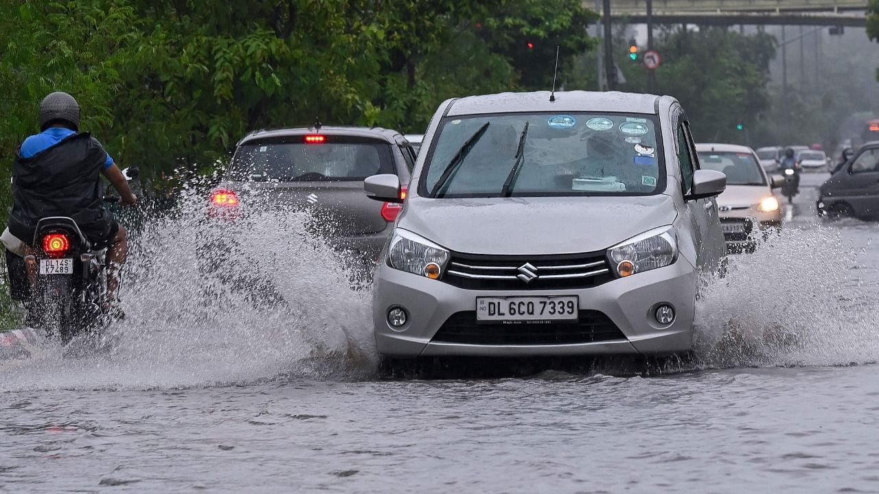 Vehicles drive along a water-logged road during heavy monsoon rains in New Delhi. Credit: AFP Photo
