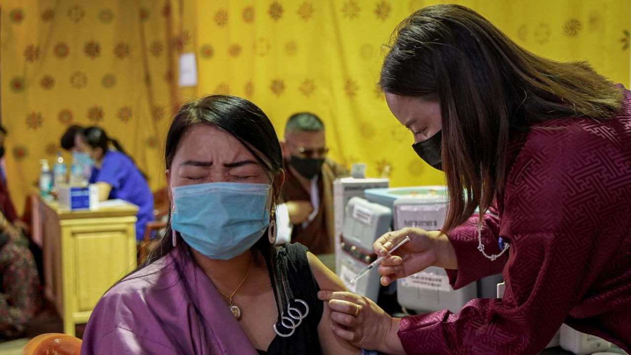 A health worker inoculates a woman with the jab of the Covid-19 vaccine at a temporary vaccination centre in Thimpu. Credit: AFP Photo