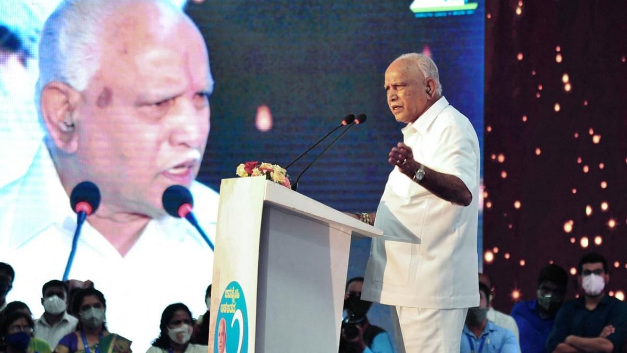 Karnataka chief minister BS Yediyurappa (R) speaks at a function held to celebrate two years of Bharatiya Janata Party (BJP) rule in the state before tendering his resignation to his post. Credit: AFP Photo