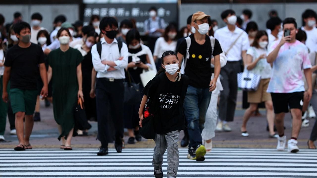 Pedestrians wearing protective masks amid the coronavirus disease outbreak, walks on crosswalk in Tokyo, Japan. Credt: Reuters Photo