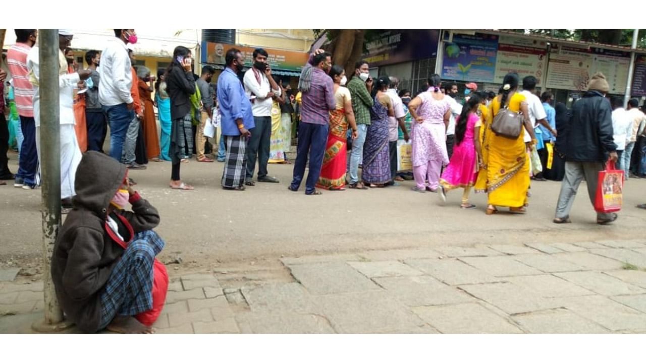 Patients wait near counters of KR Hospital in Mysuru on Tuesday as there was a problem in the billing software. Credit: DH Photo