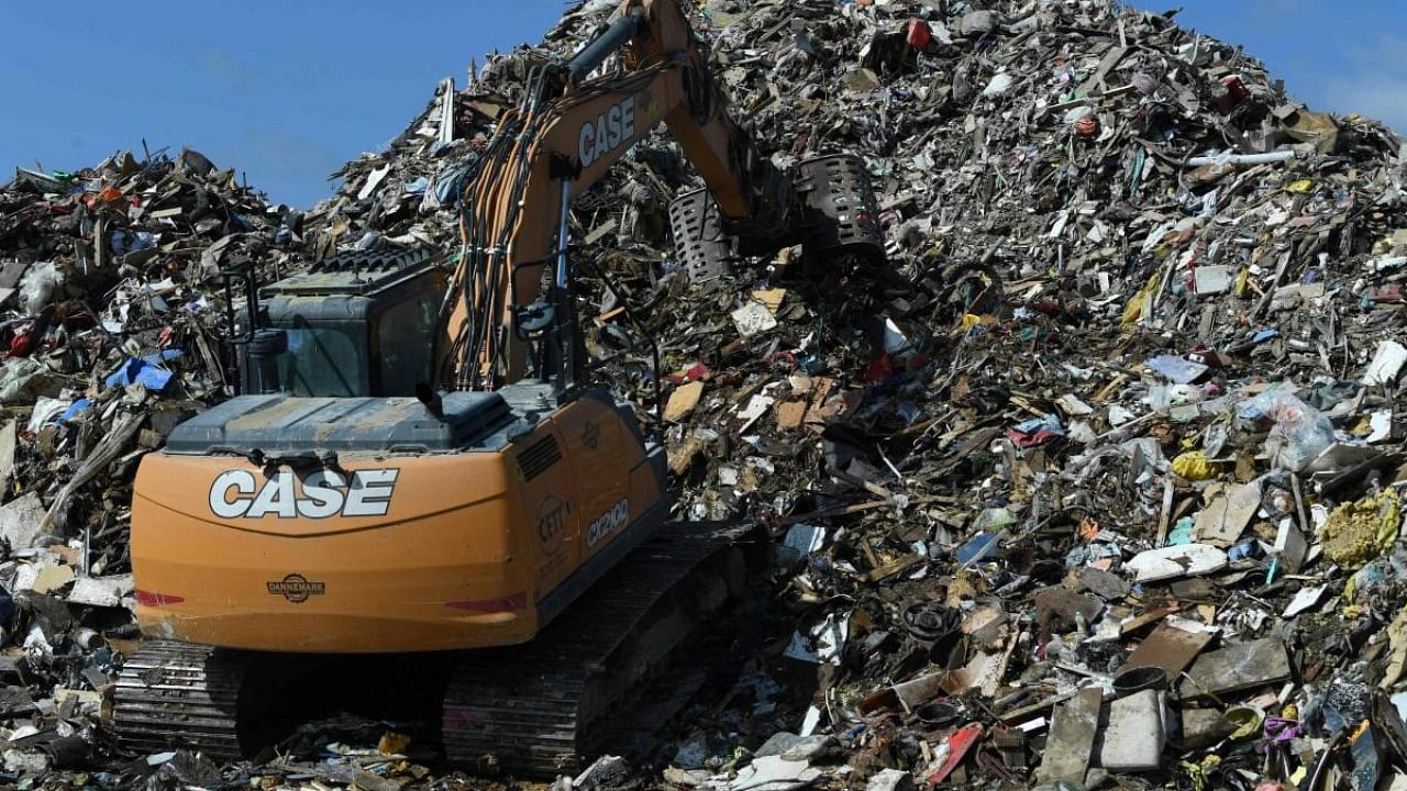 A digger piles rubbish collected from the flooded areas, at a landfill in Rochefort, Belgium, earlier in July. Climate change impacts and conflicts are more apparent now and a truly sustainable model of development has become the only way forward. Credit: AFP file photo