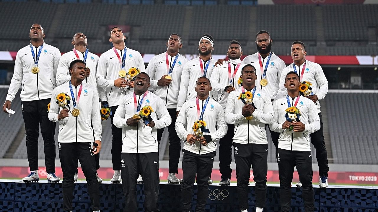 Fiji's players sing on the podium with their gold medals after the victory ceremony following the men's final rugby sevens match at the Tokyo Olympics. Credit: AFP Photo