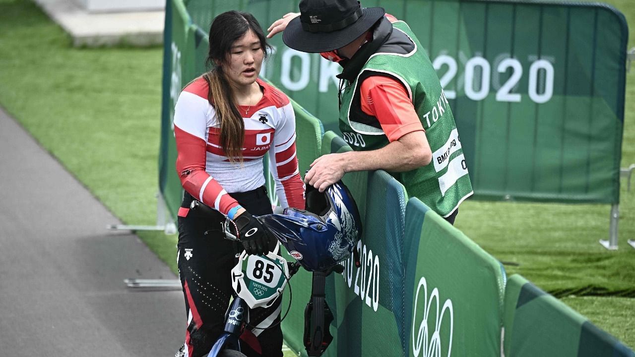 Japan's Sae Hatakeyama is comforted by her coach after falling in the cycling BMX racing women's quarter-finals run. Credit: AFP Photo