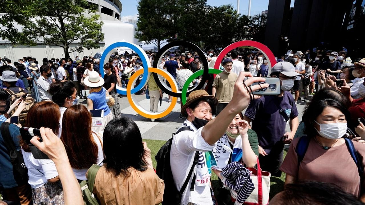 People crowd around the Olympic Rings monument near the Olympic Stadium in Tokyo, Japan. Credit: Reuters Photo