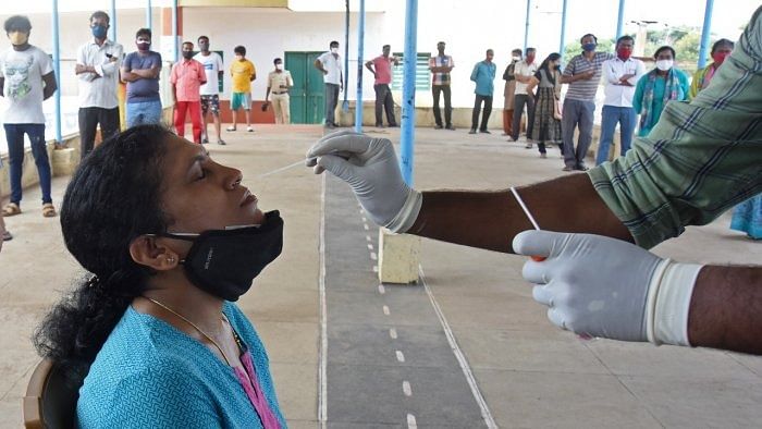 A healthcare worker conducts swab test for coronavirus. Credit: DH Photo