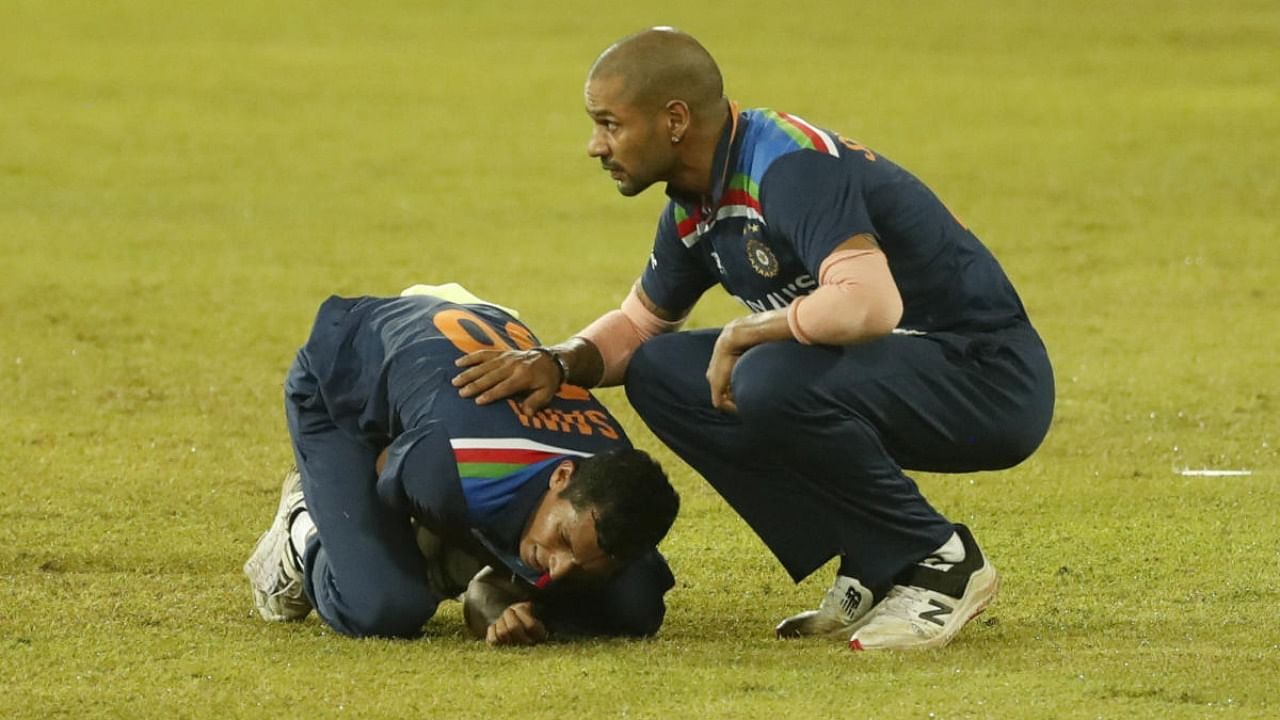  India's Navdeep Saini holds his arm in pain as Shikhar Dhawan attends during their second Twenty20 cricket match with Sri Lanka in Colombo, Sri Lanka. Credit: AP Photo