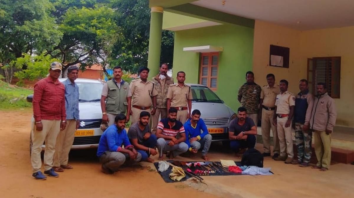 Forest department personnel with the accused and the seized weapons in Chamarajanagar. Credit: DH Photo