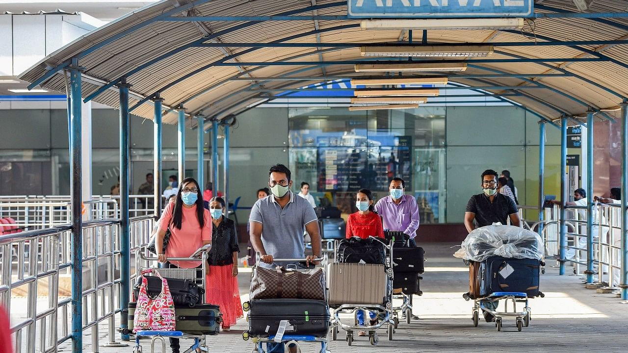 Passengers wear medical-masks as part of precautionary measures against coronavirus, at Chennai International Airport. Credit: PTI File Photo