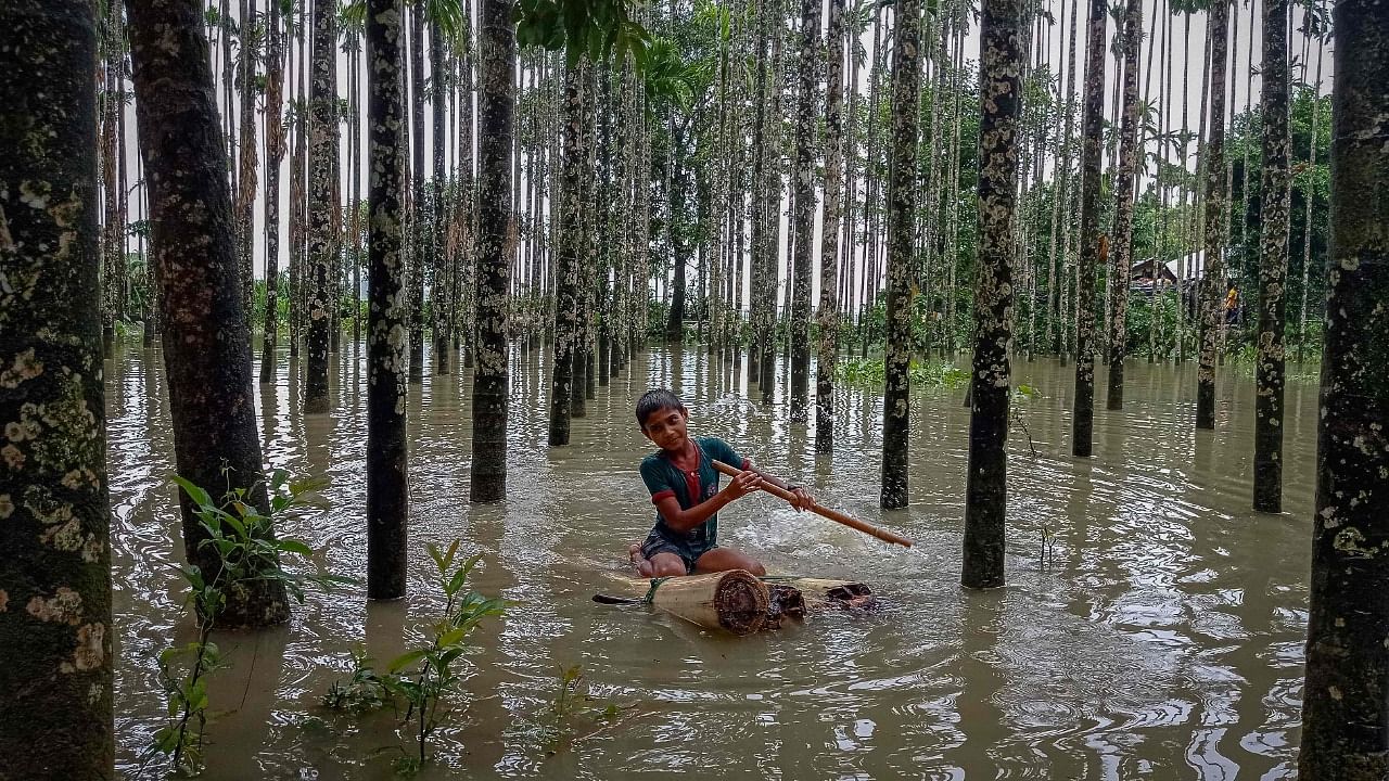 A child wades through a flooded area using a makeshift raft at Maulovir Para, Cox's Bazar. Credit: AFP Photo