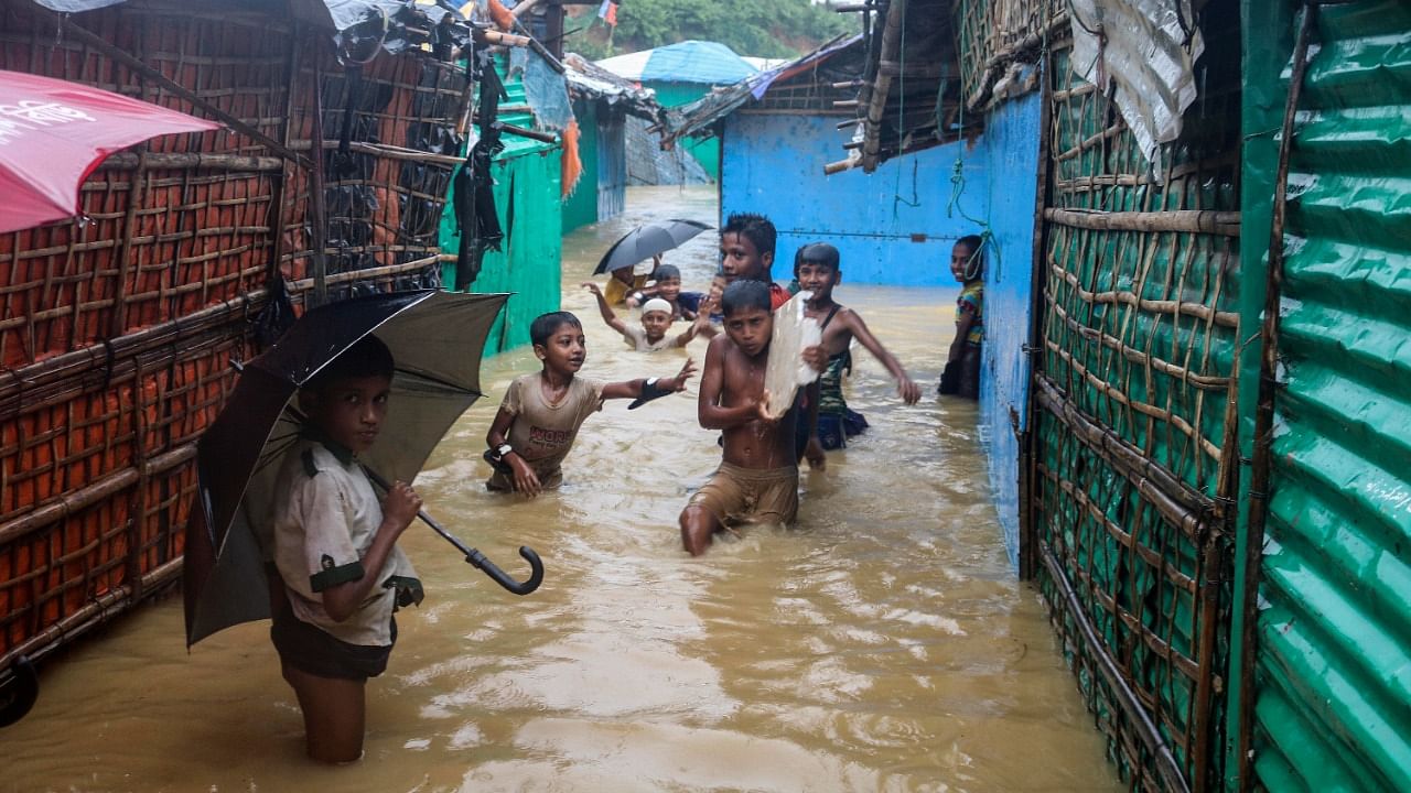 Rohingya refugee children play in flood waters at the Rohingya refugee camp in Kutupalong, Bangladesh. Credit: AP/PTI Photo