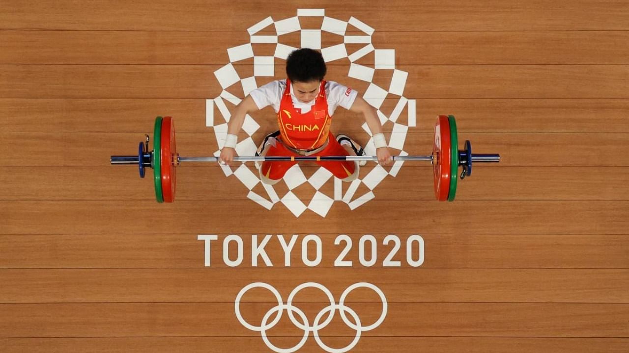 Hou Zhihui of China won weight lifting gold in the women’s 49-kilogram division in Tokyo and shattered three Olympic records. She is part of a fearsome Chinese squad that aimed to sweep every weight class it was contesting. Credit: Reuters photo