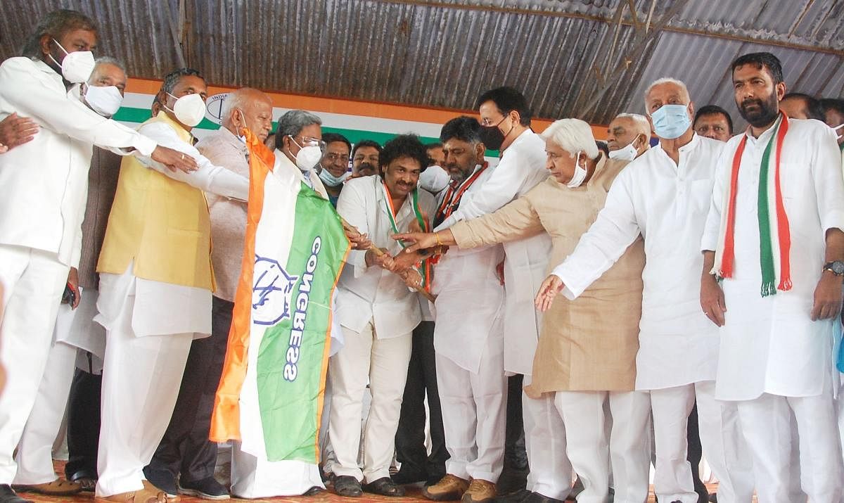 Madhu Bangarappa, who joined the Congress party, receives the party flag from Leader of Opposition in Assembly Siddaramaiah, KPCC president D K Shivakumar and AICC general secretary Randeep Singh Surjewala. Credit: DH Photo