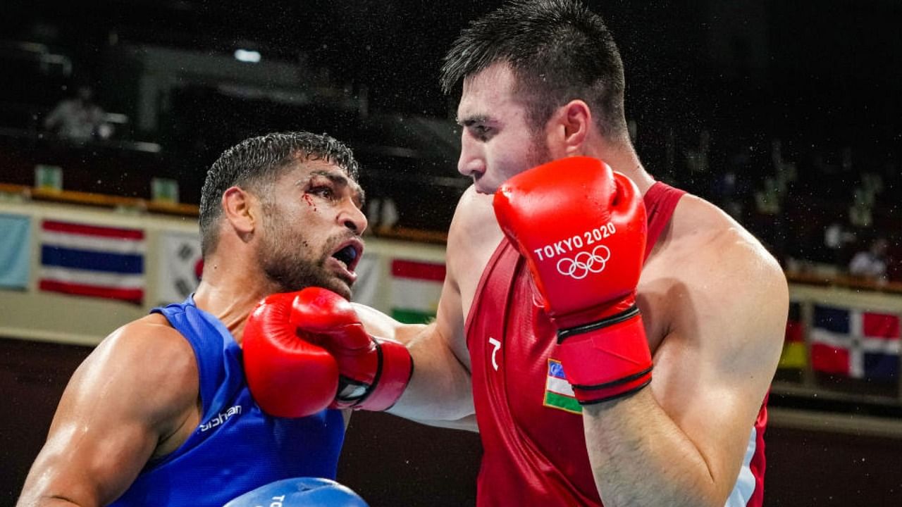 India's Satish Kumar exchanges punches with B. Jalolov of Uzbekistan during their men's super heavyweight over 91-kg boxing match at the Summer Olympics 2020 in Tokyo, Sunday, Aug. 1, 2021. Credit: PTI Photo