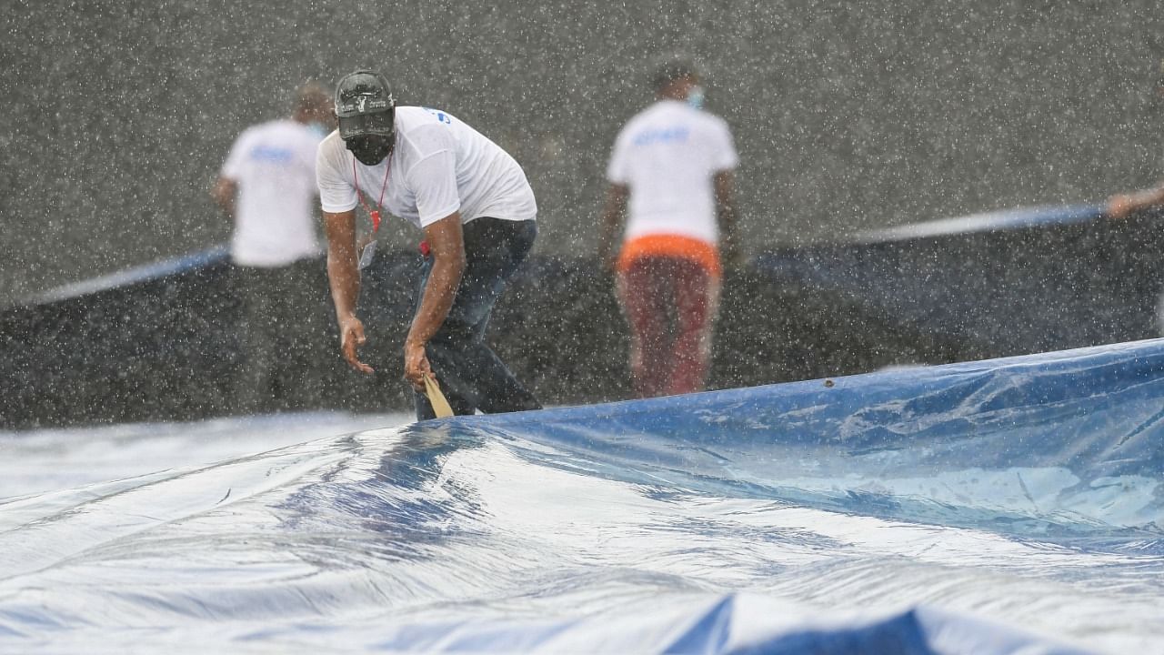 Ground staff pull on covers as the rain stopped play during the 3rd T20I match between West Indies and Pakistan at Guyana National Stadium in Providence, Guyana on August 1, 2021. Credit: AFP Photo
