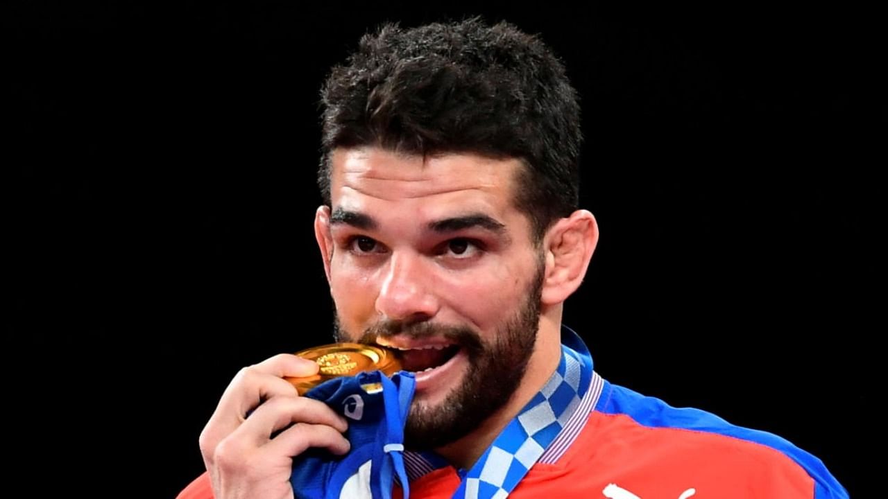 Gold medallist Luis Alberto Orta Sanchez of Cuba bites his medal. Credit: Reuters Photo