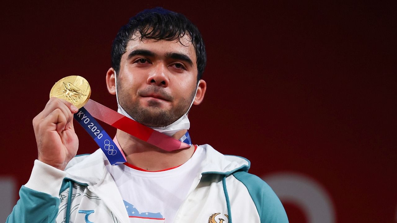 Uzbekistan's Akbar Djuraev poses with his gold medal in the men's weightlifting 109kg event. Credit: Reuters Photo