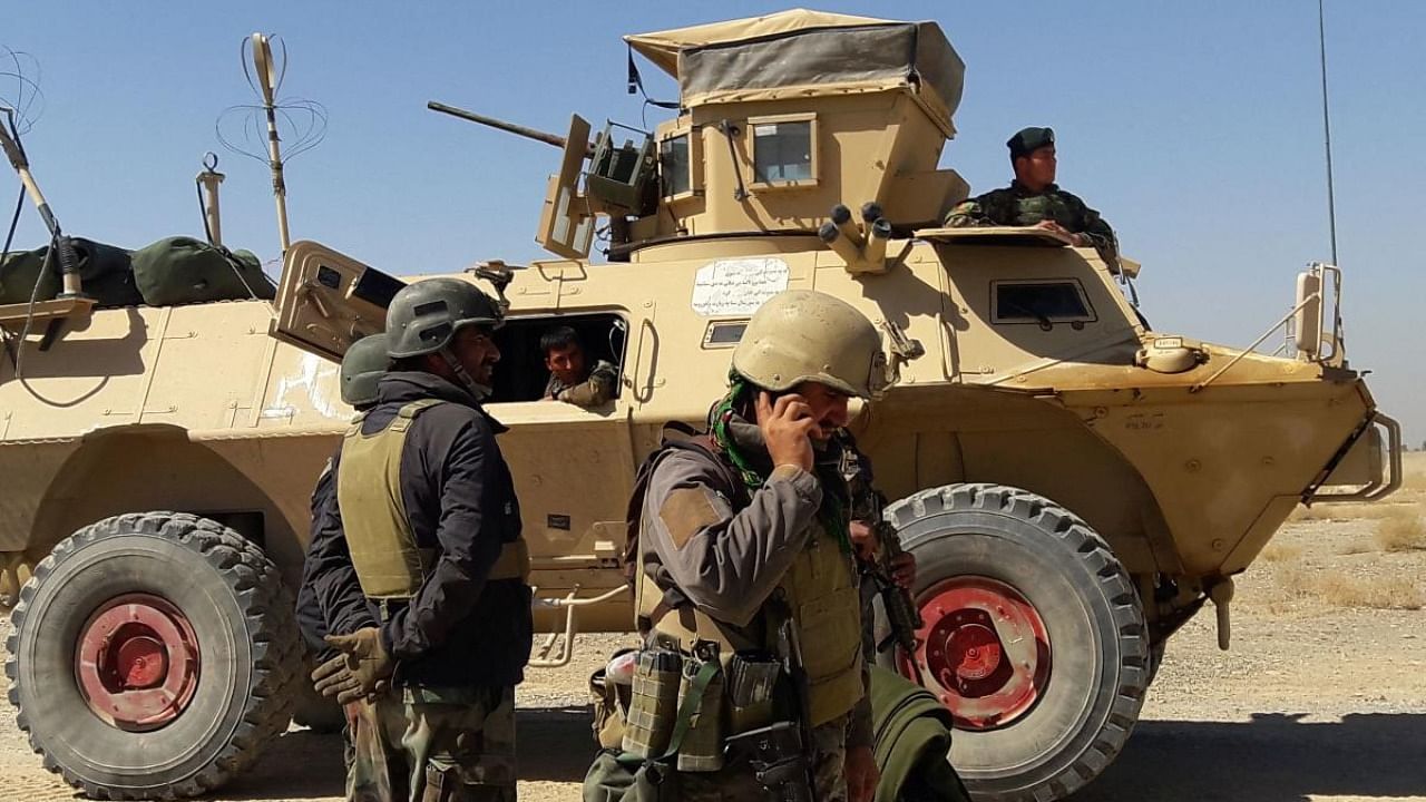 Afghan security forces stand near an armoured vehicle during ongoing fighting between Afghan security forces and Taliban fighters in the Busharan area on the outskirts of Lashkar Gah, the capital city of Helmand province. Credit: AFP file photo