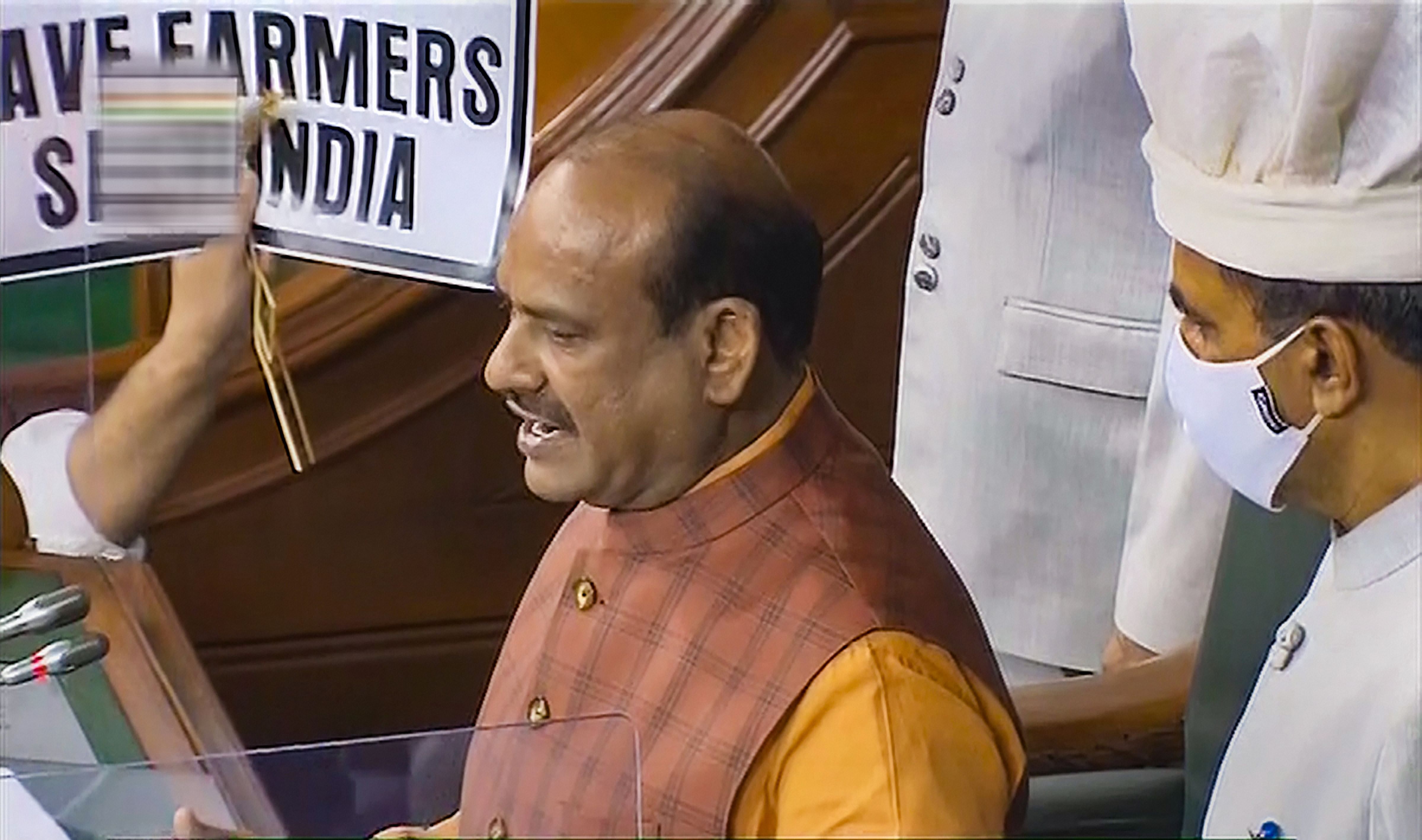  Lok Sabha Speaker Om Birla conducts proceedings as opposition members display placards to protest over farmers' issues, during the Monsoon Session of Parliament, in New Delhi. Credit: PTI Photo
