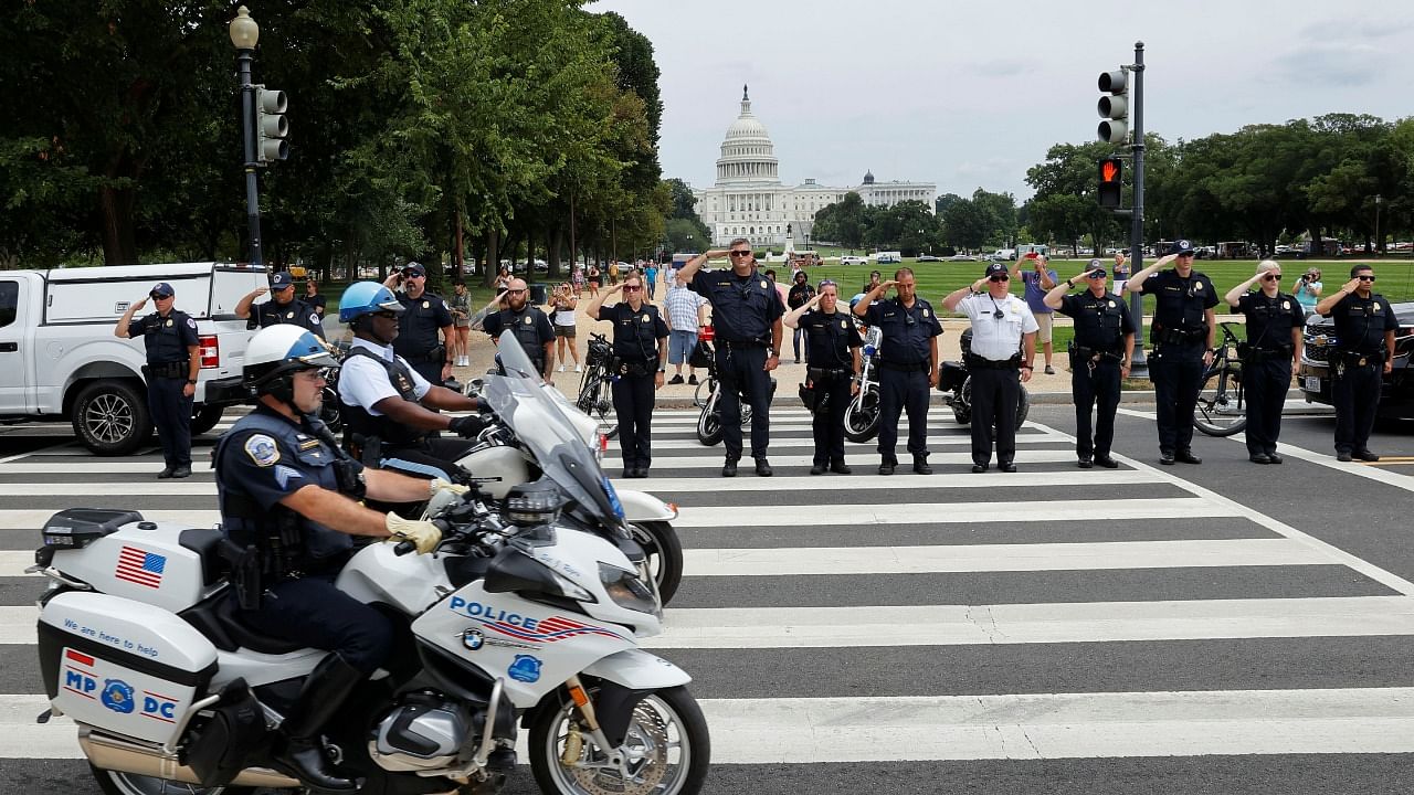 Law enforcement officers salute as a ceremonial procession in honour of a police officer wounded at the Pentagon passes the US Capitol in Washington. Credit: Reuters Photo