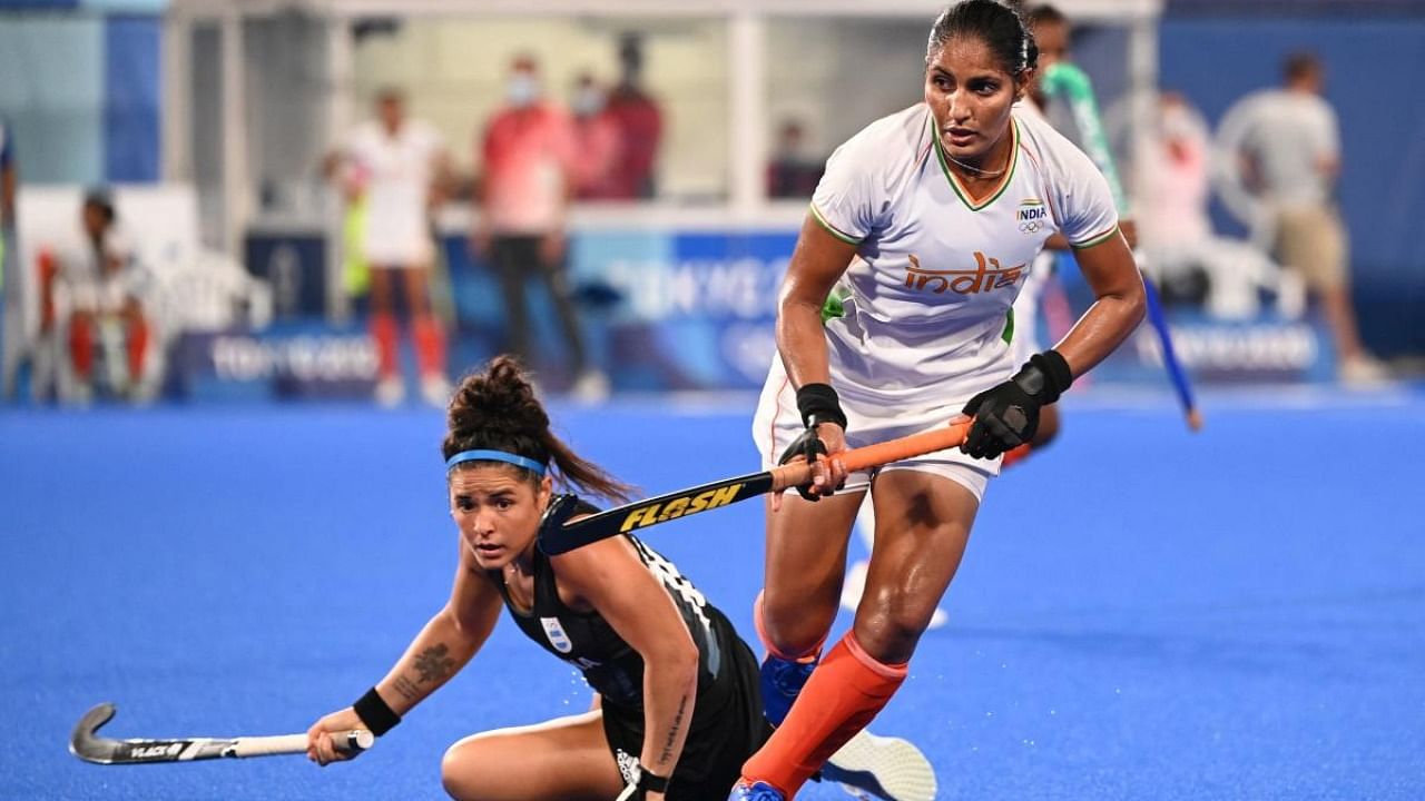 India's Gurjit Kaur (R) carries the ball past Argentina's Maria Jose Granatto during their women's semi-final match of the Tokyo 2020 Olympic Games field hockey competition. Credit: AFP Photo