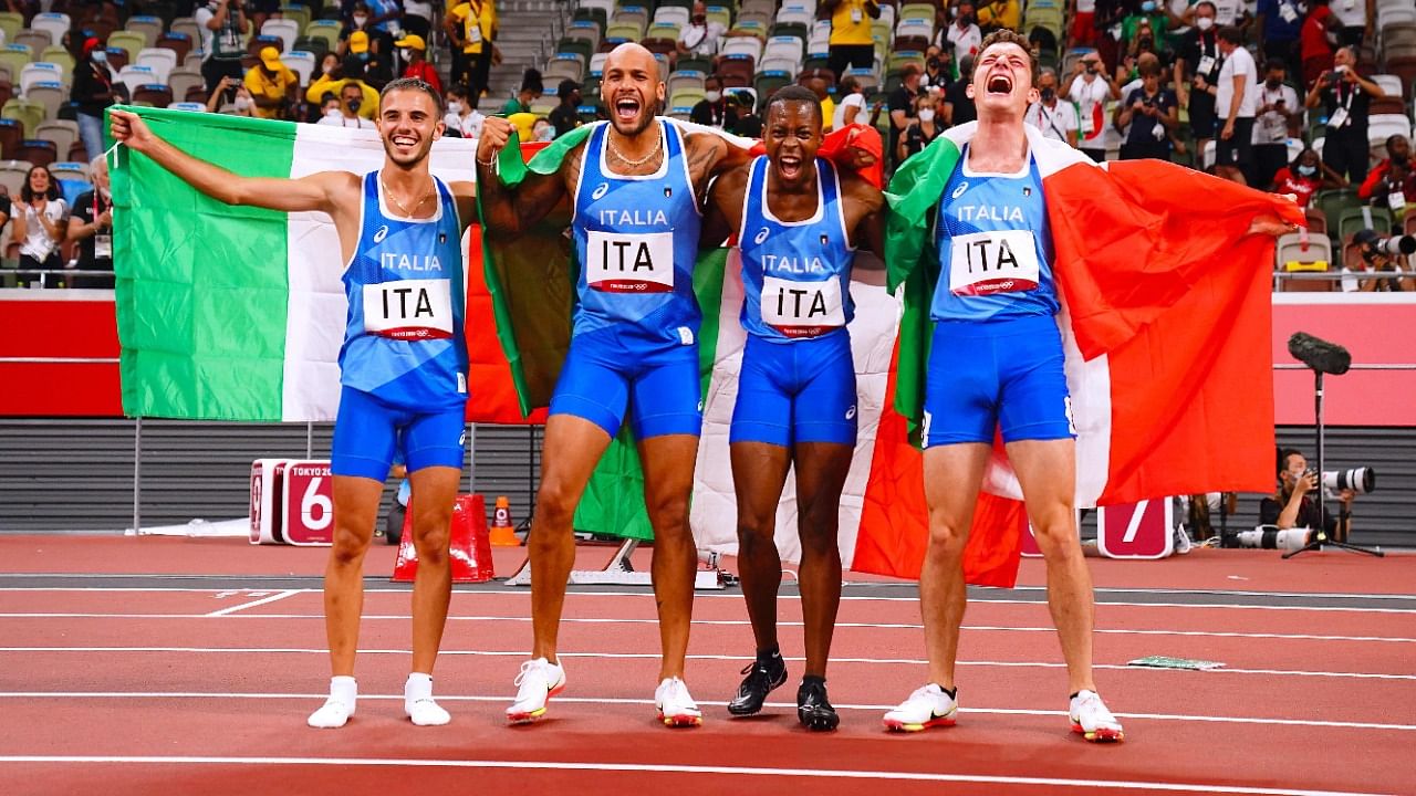 (L to R) Italians Lorenzo Patta, Lamont Marcell Jacobs, Eseosa Desalu and Filippo Tortu celebrate their 4x100m relay win. Credit: AFP Photo