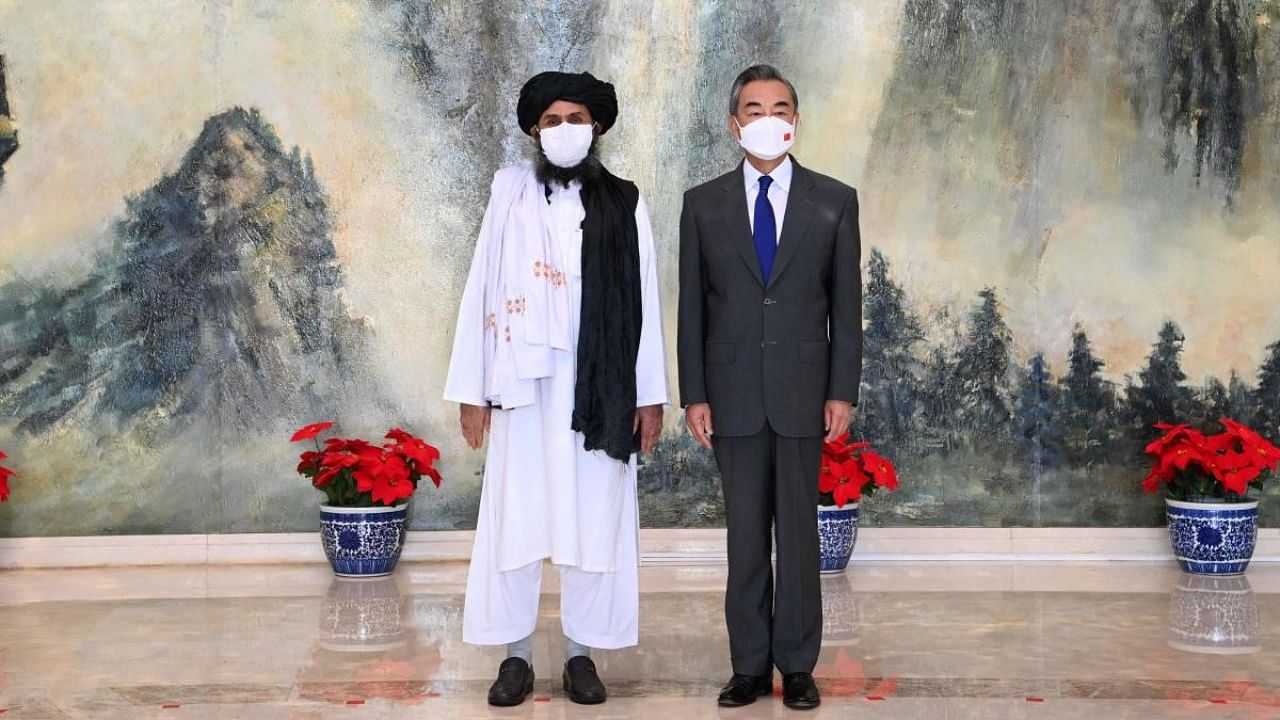 This photo taken on July 28, 2021, and released by China's Xinhua News Agency shows Chinese State Councilor and Foreign Minister Wang Yi (R) meeting with Mullah Abdul Ghani Baradar, political chief of Afghanistan's Taliban, in Tianjin. Credit: AFP Photo/Xinhua/Li Ran