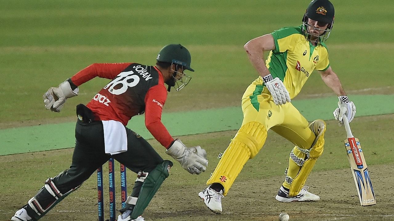 Australia's Ashton Turner (R) plays a shot as Bangladesh's wicketkeeper Nurul Hasan tries to catch the ball during the fourth T20. Credit: AFP Photo