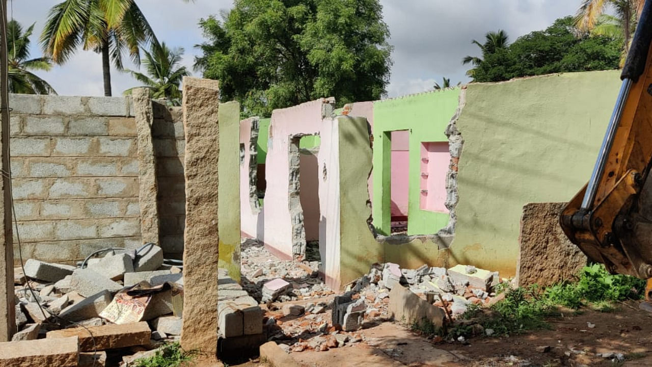 Photo caption: District administration officials bring down a building illegally constructed on government land in Anagalapura village in Bengaluru East taluk. Credit: Special Arrangement