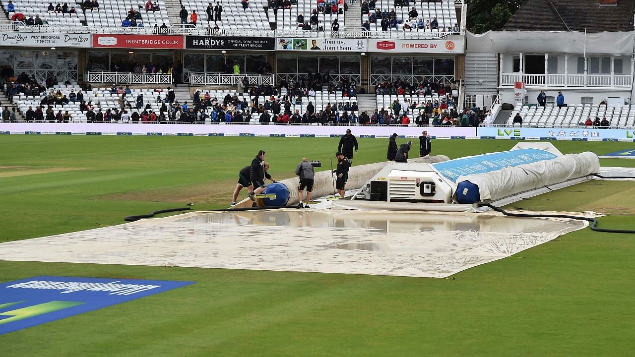 Groundsmen cover the pitch area after rain delayed start of the fifth day of first test cricket match between England and India, at Trent Bridge in Nottingham. Credit: AP/PTI Photo