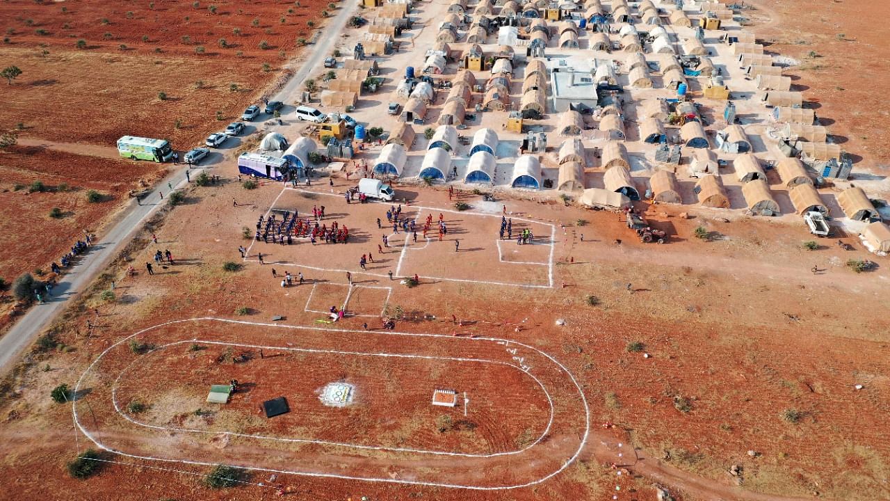 This aerial view shows a field at a camp for displaced Syrians hosting the so-called "Camp Olympics 2020" in the town of Fuaa, in the northwestern Syrian last major rebel bastion of Idlib, on August 7, 2021, as 120 boys from 12 different camps gather for their own version of the Olympic games, at the end of the Tokyo Olympics. Credit: AFP Photo