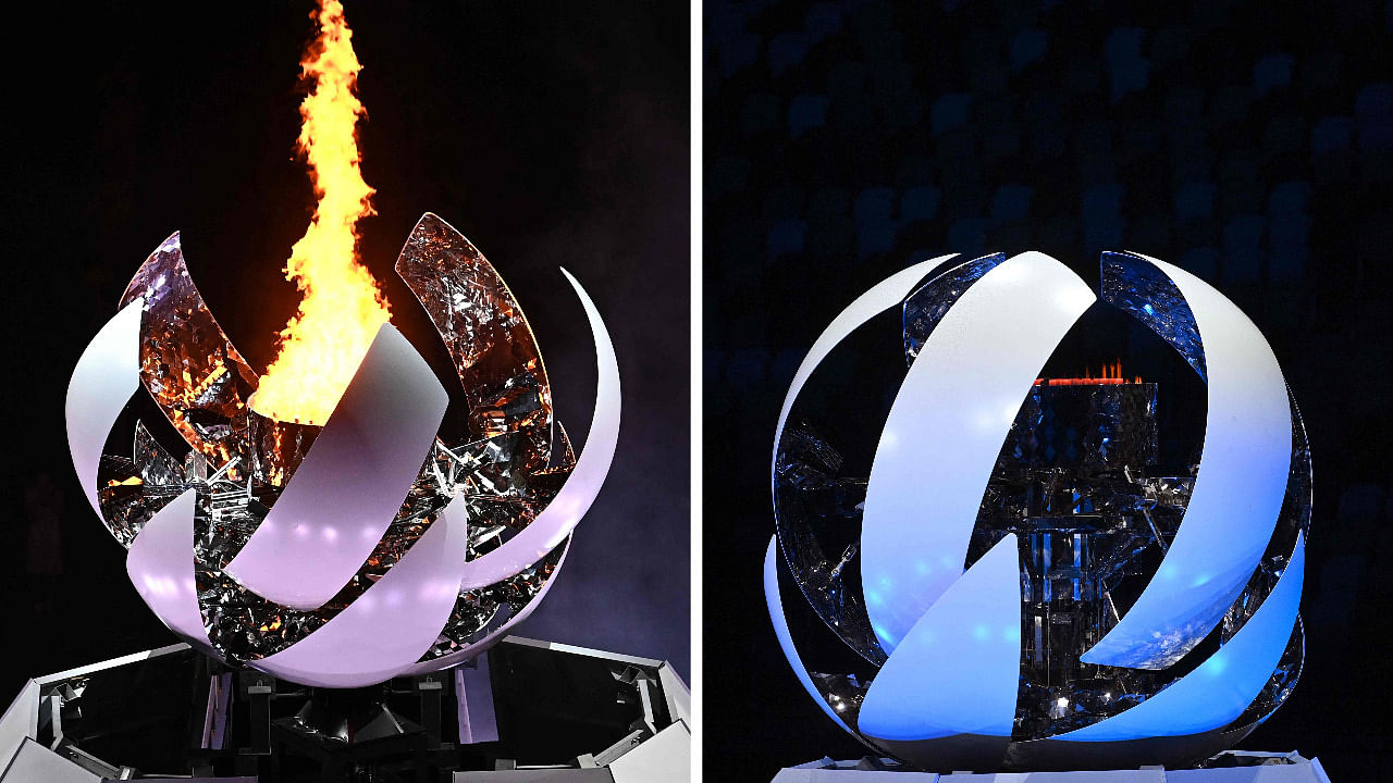 A combination of pictures created on August 8, 2021 shows the Olympic flame burning (L) in the cauldron at the Olympic Stadium during the opening ceremony of the Tokyo 2020 Olympic Games, in Tokyo, on July 23, 2021 and another of the Olympic cauldron closing (R) as the Olympic flame is extinguishing during the closing ceremony of the Tokyo 2020 Olympic Games at the Olympic Stadium in Tokyo. Credit: AFP Photo