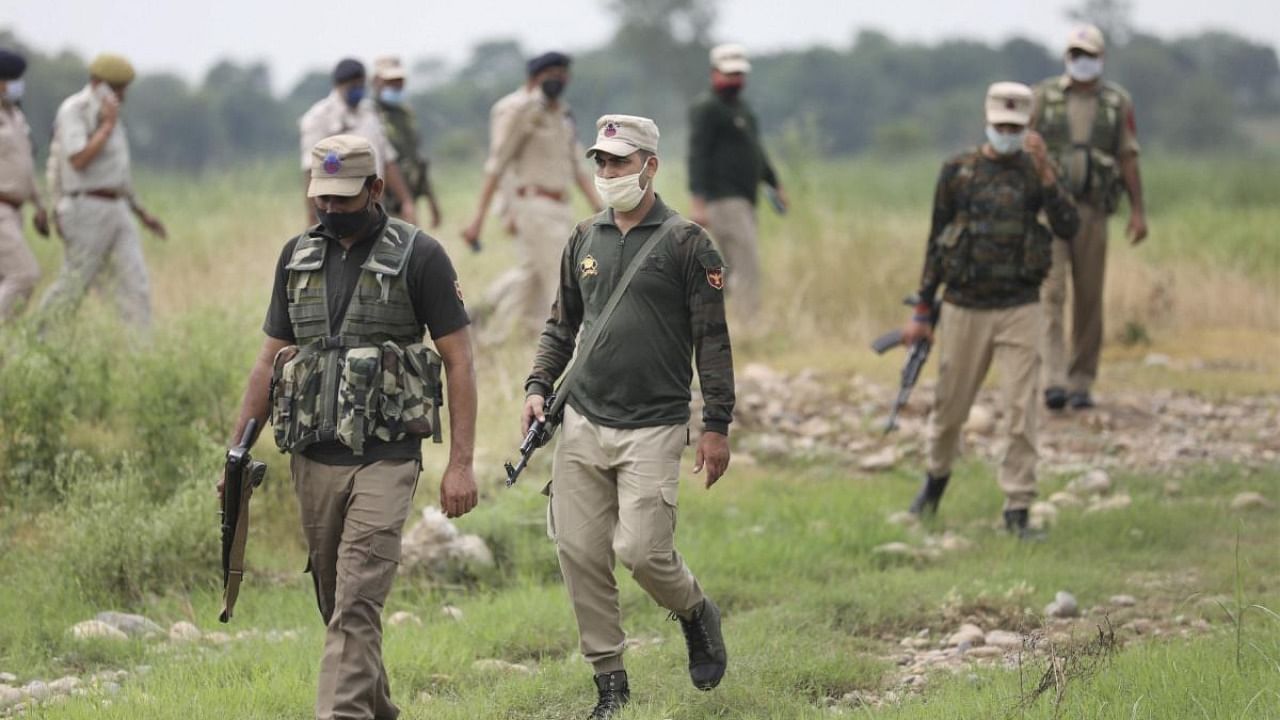 Special Operation Group (SOG) personnel patrol after a consignment of arms and ammunition recovered during a search operation in Samba district, Friday. Credit: PTI Photo