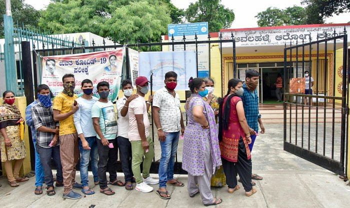 People wait in a queue for Covid vaccination at a government health centre in Avalahalli, Bengaluru on Sunday. Credit: DH Photo/Prashanth H G