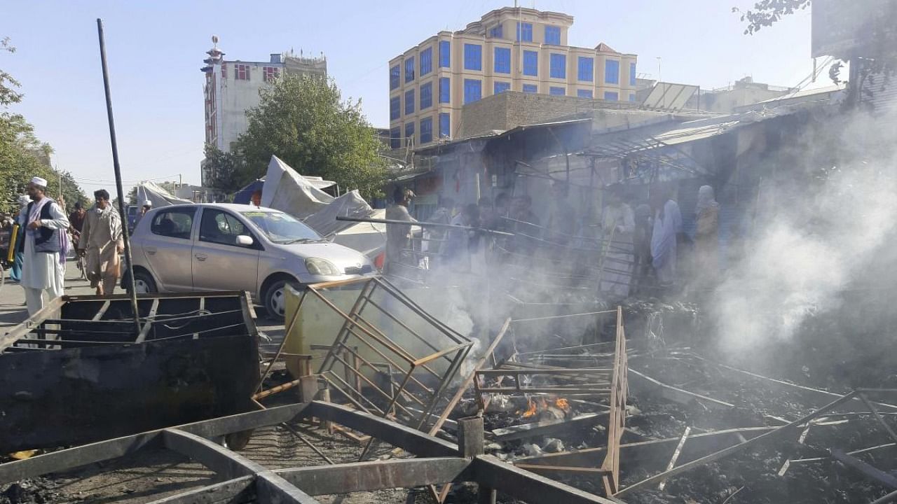 Smoke rises from damaged shops after fighting between Taliban and Afghan security forces in Kunduz city, northern Afghanistan, Sunday, August 8, 2021. Credit: AP Photo