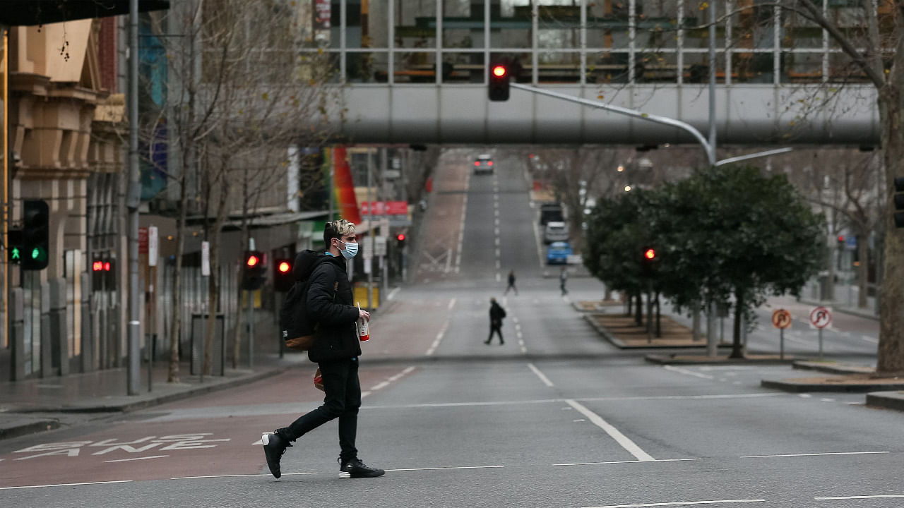 A pedestrian crosses a street in downtown Melbourne on August 6, 2021, amid a sixth lockdown for the city in efforts to bring the Delta outbreak to heel. Credit: AFP Photo