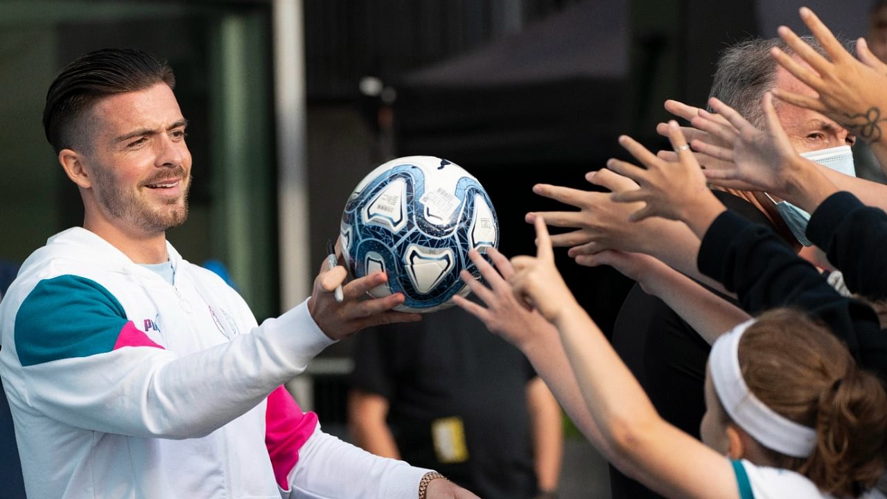 Jack Grealish hands a football to supporters. Credit: AP Photo