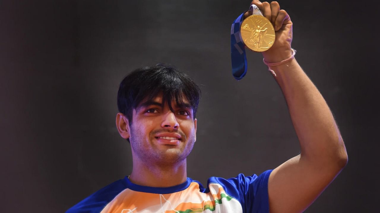 Neeraj Chopra, who won gold medal in the javelin throw event of the recently concluded Tokyo Olympics 2020, shows his medal at a press conference in New Delhi. Credit: PTI Photo