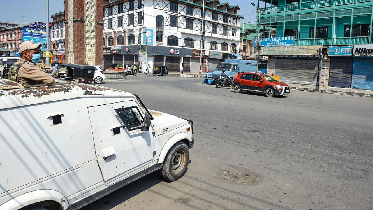 A security personnel stands guard in an armoured vehicle during a strike on the second anniversary of the abrogation of Art 370, in Srinagar. Credit: PTI Photo