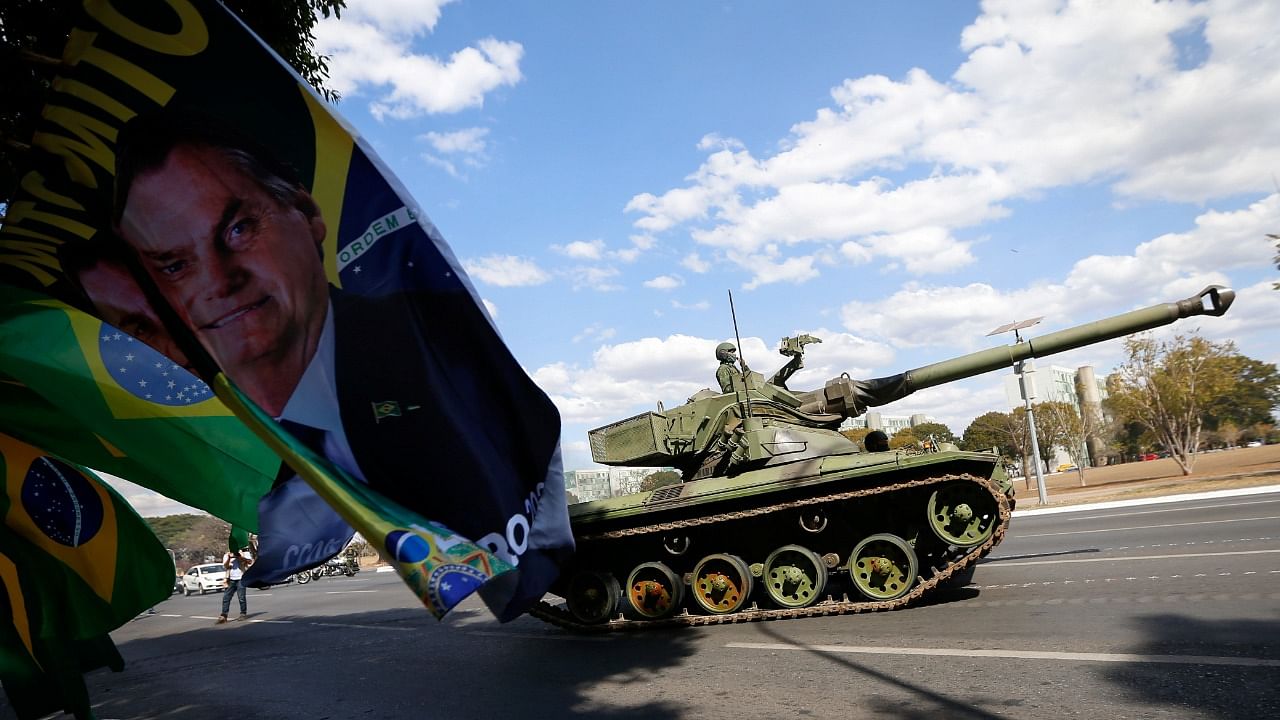 Brazilian Navy tanks pass next flags with the image of Brazil's President Jair Bolsonaro at the Esplanade of Ministries. Credit: Reuters photo