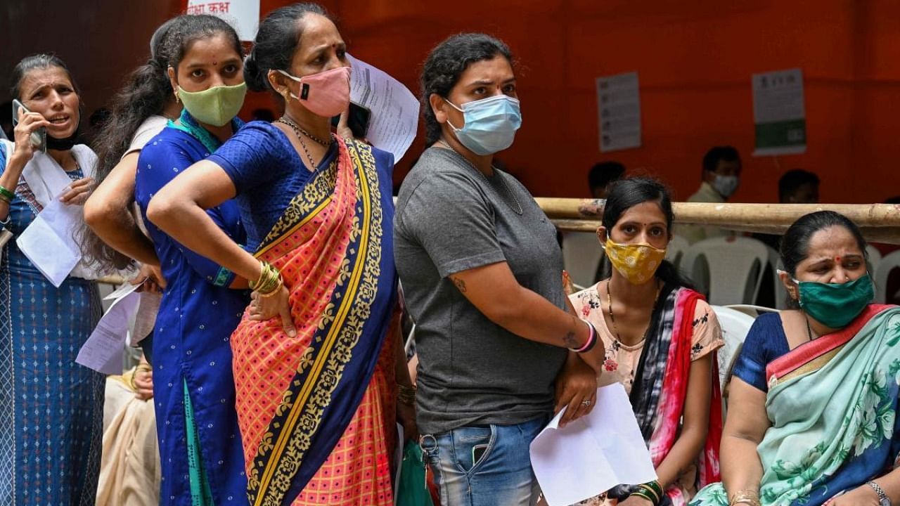 Residents queue up to get inoculated with a dose of Covaxin vaccine against the Covid-19 coronavirus at a temporary vaccination centre set up in a school in Mumbai on August 10, 2021. Credit: AFP Photo