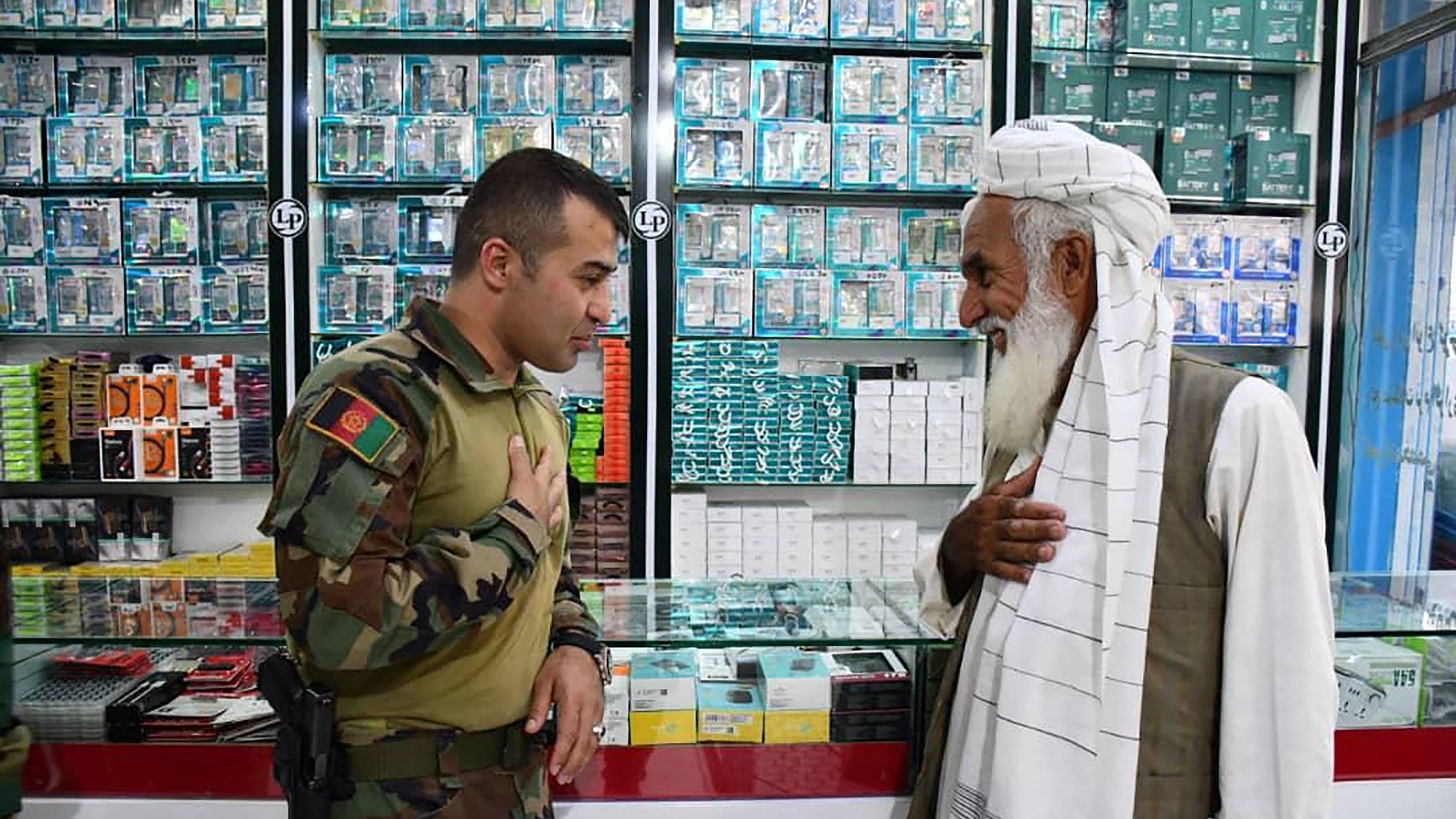 Sami Sadat (L), commander of the 215 Maiwand Afghan Army Corps, greets a man in the city of Zaranj in Nimruz province. Credit: AFP Photo by HANDOUT / Public Relation Office of 215 Maiwand corps