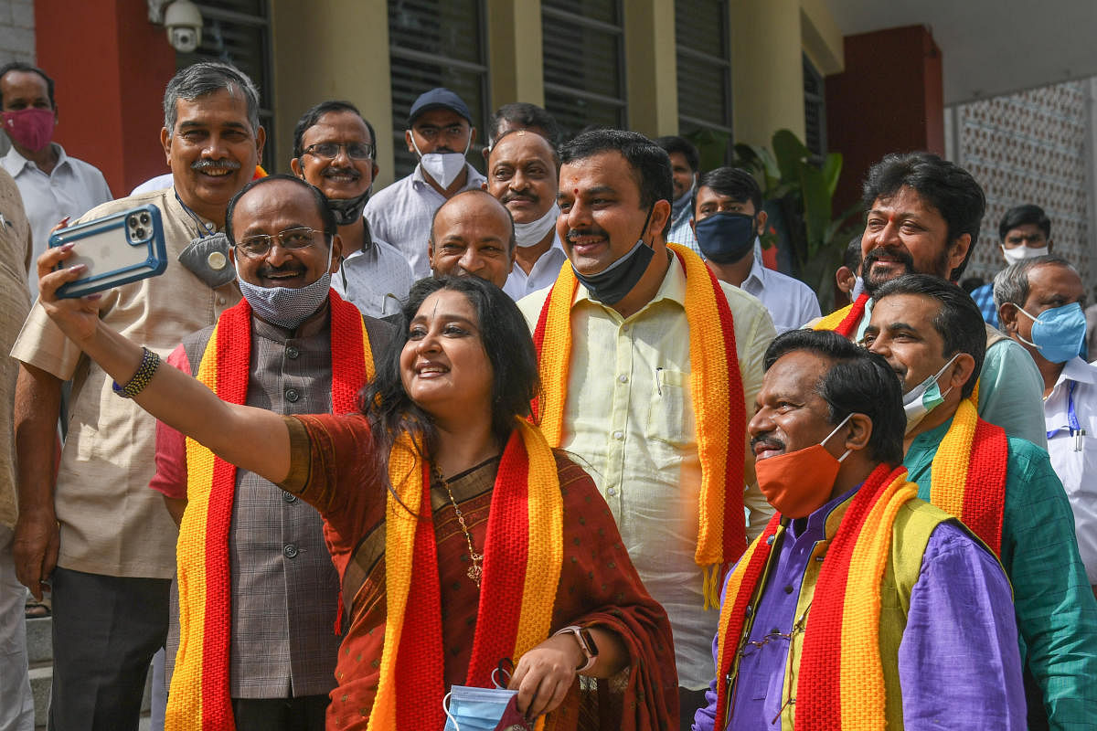 BJP functionary Malavika Avinash takes a selfie with Minister for Kannada &amp; Culture V Sunil Kumar after he assumed the office at Ravindra Kalakshetra in Bengaluru on Wednesday. Chiefs of various academies B V Rajaram, Mahendra, T S Nagabharana and Sun. Credit: DH Photo