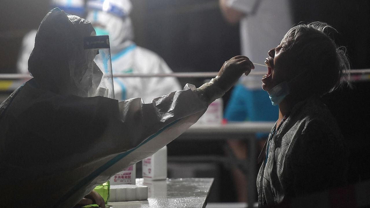 A health worker administers a Covid-19 test in Wuhan. Credit: AFP Photo