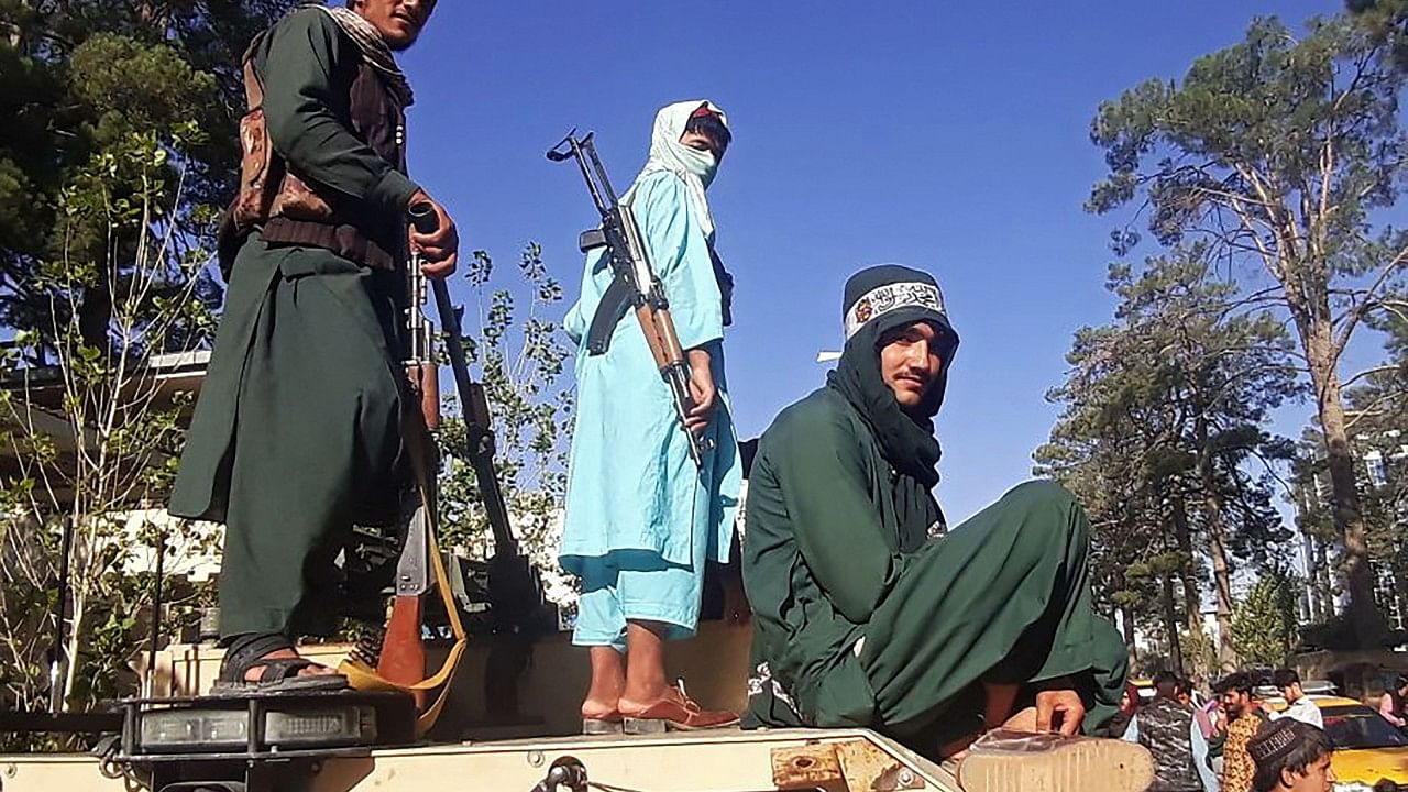 Taliban fighters stand on a vehicle along the roadside in Herat. Credit: AFP Photo