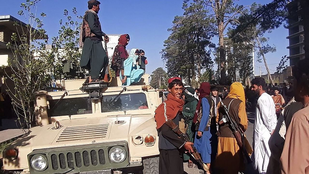 Taliban fighters stand guard along the roadside in Herat, Afghanistan's third biggest city, after government forces pulled out the day before following weeks of being under siege. Credit: AFP File Photo